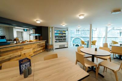 Counter and tables in the Norwich Castle restaurant with the wall of the Keep in the background