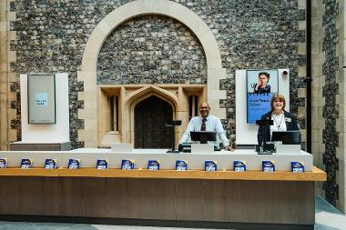 Staff ready to welcome visitors at the new ticket desk at Norwich Castle. Behind them is the east wall of the Castle Keep.